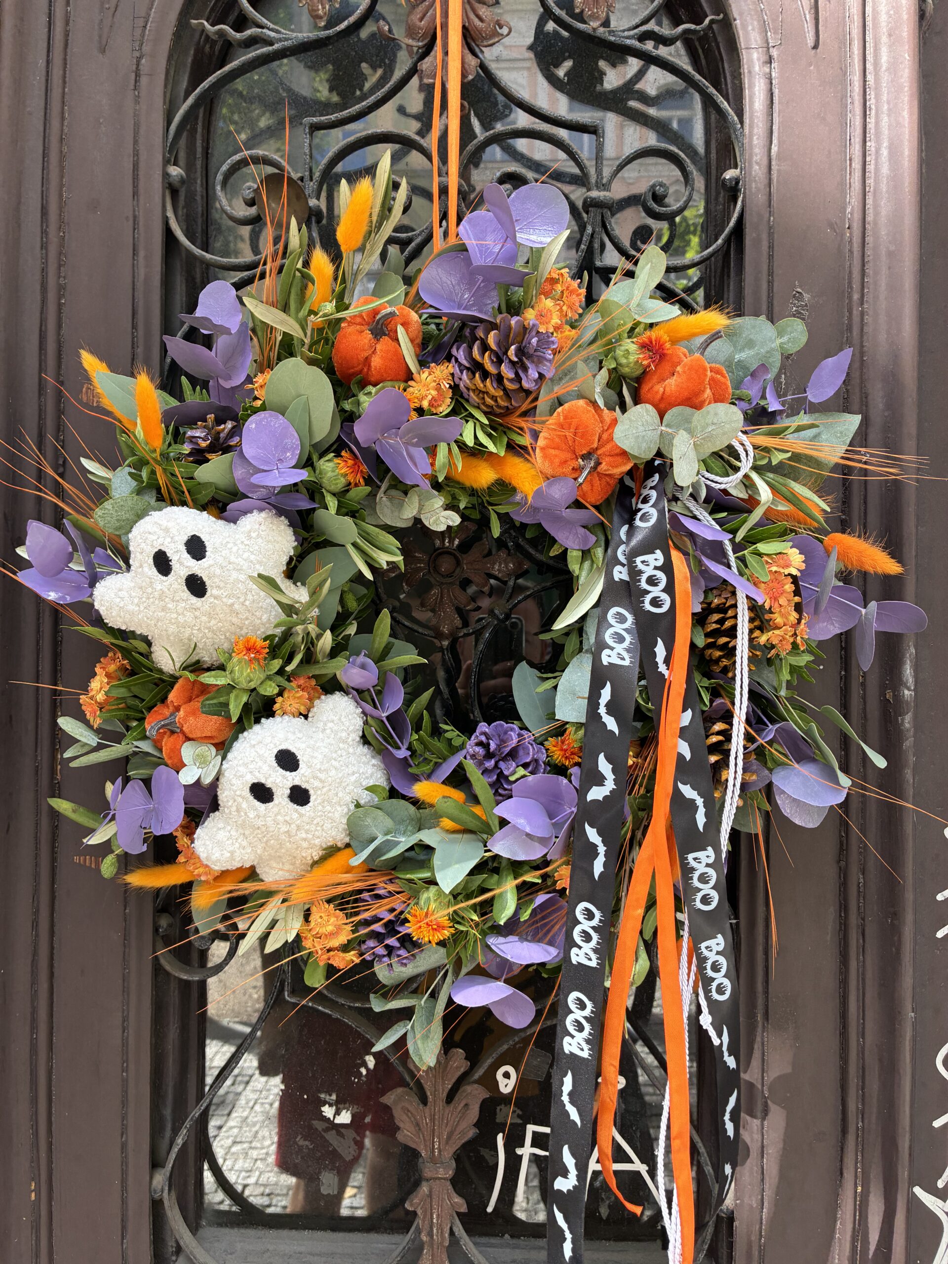 Halloweenský věnec s duchy zavěšený na dveřích