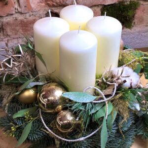 Adventní věnec se čtyřmi bílými svíčkami, zlatými baňkami a bavlnou