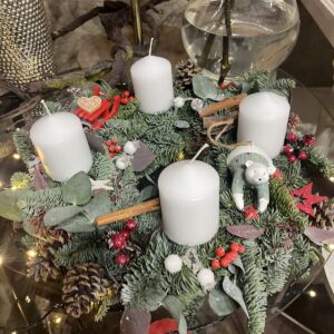 Adventní věnec s bílými svíčkami, ledním medvídkem a skořicí