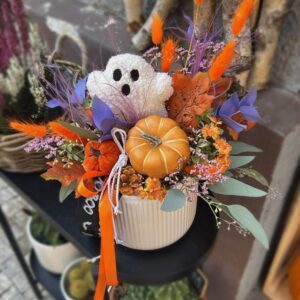 Halloweenská dekorace v béžovém květináči s plyšovým duchem a oranžovou dýní